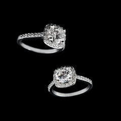 Luxury jewellery. White gold or silver engagement rings with diamonds closeup on black background....