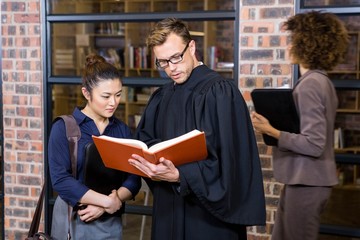 Fototapeta na wymiar Lawyer and businesswoman reading law book