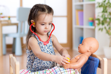 child playing doctor with doll indoor