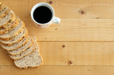 Flat lay of whole wheat bread and and coffee on wooden table.copy space