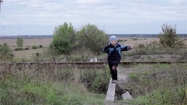 run by Wooden/boy running through the tracks and wooden bridge in nature