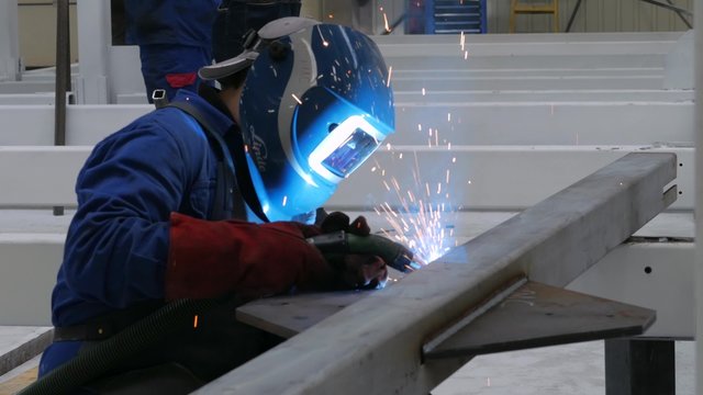 A welder working on the metals and pipes in the factory
