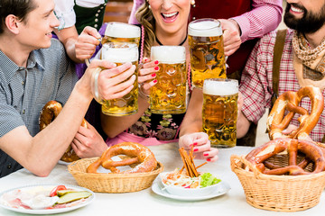 Maßkrüge und Brezn in Biergarten Bayern, closeup auf das Essen und die Getränke