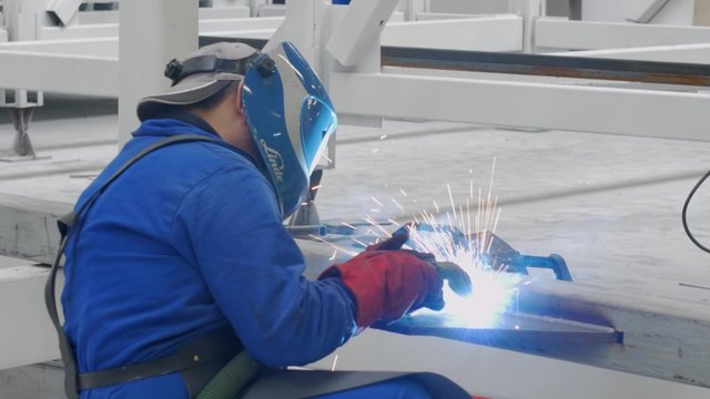 A welder working on the metals and pipes in the factory
