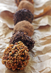 Assorted dark chocolate truffles with cocoa powder,chopped hazelnuts over baking paper