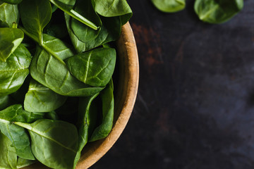 Fresh spinach leaves in a wooden bowl