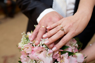 Obraz na płótnie Canvas Hands of the groom and bride with rings and bridal bouquet of flowers