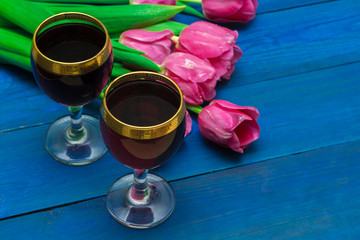 two glasses of red wine and tulips