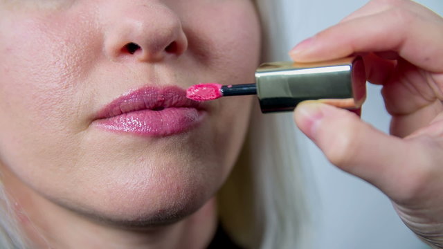 Applying lipstick on the costumers lips 