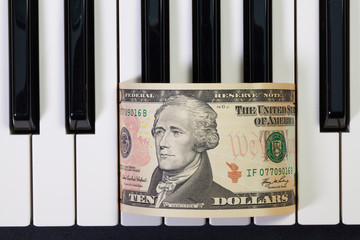 Piano keyboard and US dollar banknote