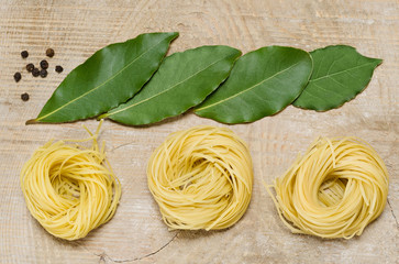 Not cooked pasta and spices lying on the old Board