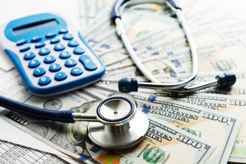 Health insurance application form with banknote and stethoscope