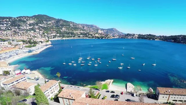 Panoramic view of coastline and beach with blue sky, luxury resort and bay with yachts, Nice port, Villefranche-sur-Mer, Nice, Cote d'Azur, French Riviera.