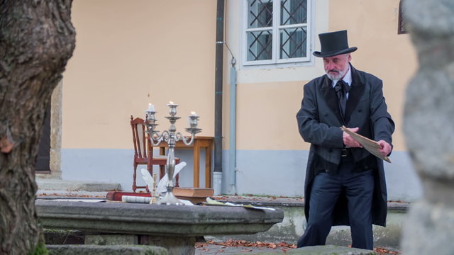 Man walking towards the writing garden table to start reading 