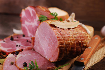 pieces of fresh smoked ham on rural background