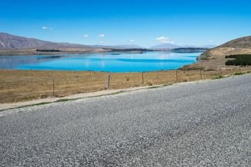 Fototapeta na wymiar asphalt road near lake in summer day in New Zealand