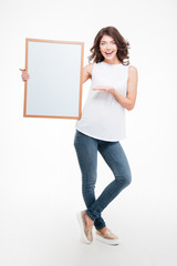 Cheerful woman holding blank board