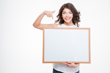 Naklejka premium Smiling woman pointing finger on blank board