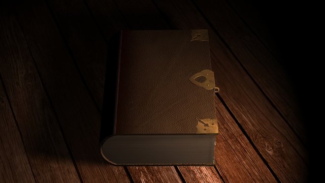 Old leather book on wooden table in candlelight