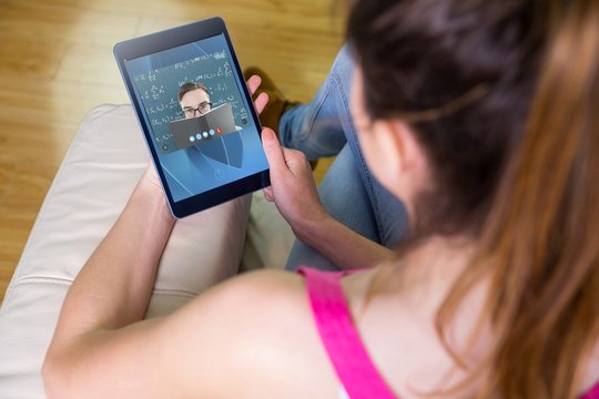 Composite image of woman using tablet at home