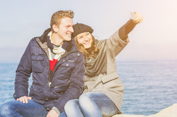 Couple of lovers taking a selfie at the beach