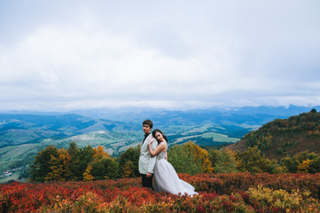 Naklejka na ściany i meble happy newly married couple posing in the mountains