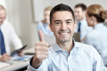 group of smiling businesspeople meeting in office