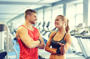 Fototapeta na wymiar smiling man and woman talking in gym