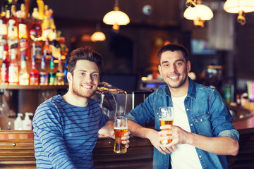 happy male friends drinking beer at bar or pub