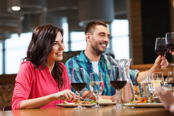 friends clinking glasses of wine at restaurant