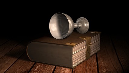 Old book and wine goblet on wooden table in candlelight