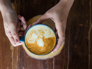 Woman hands holding mug of hot coffee drink