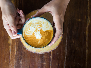 Female hands with ring holding cups of coffee