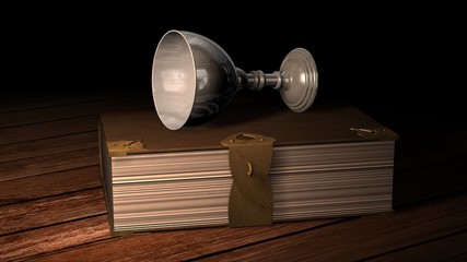 Old book and wine goblet on wooden table in candlelight