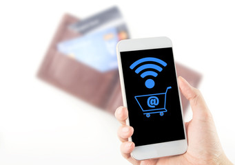 smartphone in hand with wi-fi shopping cart icon blurred wallet and credit card background
