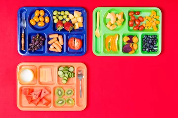 Raamstickers Three kids lunch trays with fruit © Ozgur Coskun