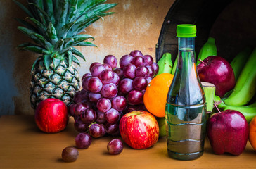Bottles of juice and fruits on a wooden