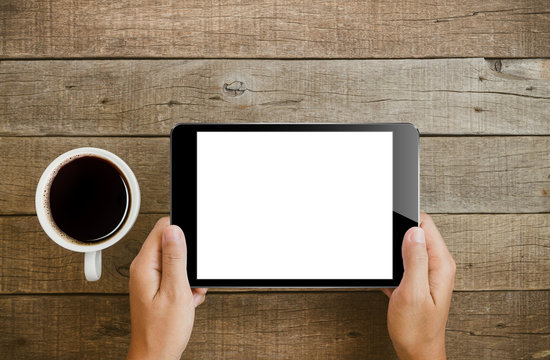 Hand Holding Tablet On Wood Table