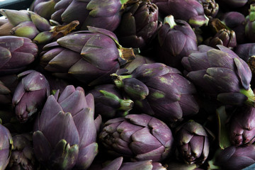 Insieme di carciofi violetti  freschi raccolti e posati su un tavolo