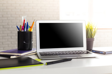 Fototapeta na wymiar Laptop with blank screen on table in office room