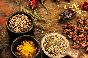 colorful spices and herbs on wooden table. Cutlery silhouette. Asian Indian cuisine ingredients. Healthy vegetarian food. Recipe, menu, mock up, cooking.