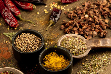 colorful spices and herbs on wooden table. Cutlery silhouette. Asian Indian cuisine ingredients. Healthy vegetarian food. Recipe, menu, mock up, cooking.