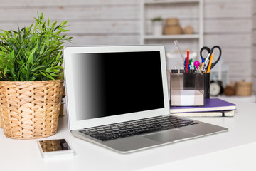 Fototapeta premium Laptop with blank screen on table in office room