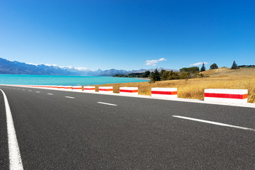 Fototapeta premium asphalt road near lake in summer day in New Zealand