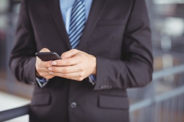 Midsection of businessman using mobile phone