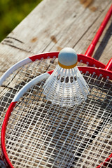 Badminton racquets with plastic shuttlecock on a bench close-up