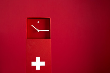 Une horloge aux couleurs du drapeau suisse, sur fond rouge