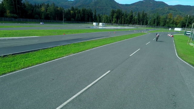 Motorbike is wheeling on a track at the automobile event