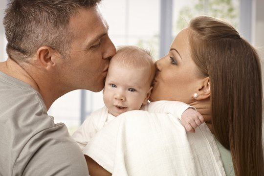 Parents kissing baby's head