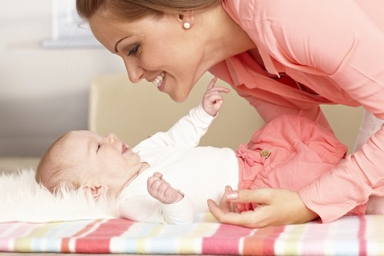 Happy mother playing with baby girl